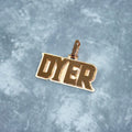 Gold pendant with 'DYER' text on a textured gray background