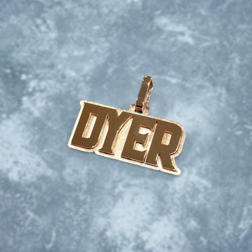 Gold pendant with 'DYER' text on a textured gray background